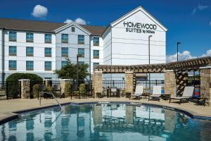 圆石城Homewood Suites by Hilton Austin/Round Rock的大楼前有游泳池的酒店