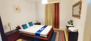 雅典Cozy room in quiet neighbourhood的一间卧室配有一张带蓝色枕头的床。