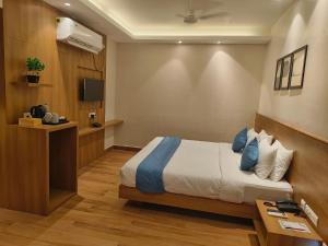迪布鲁加尔CENTRAL INN的酒店客房,配有床和电视
