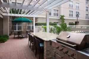 奥斯汀Homewood Suites by Hilton Austin NW near The Domain的一个带烧烤架和桌椅的庭院