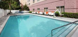 德斯坦Embassy Suites by Hilton Destin Miramar Beach的一座带椅子的大型蓝色游泳池和一座建筑