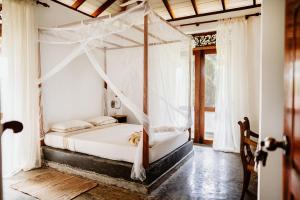 贝鲁沃勒Amuura Beach Villa的一间卧室配有一张带天蓬的床
