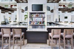 德斯坦Embassy Suites by Hilton Destin Miramar Beach的酒吧配有椅子,上面配有电视
