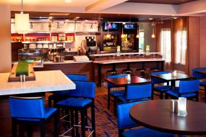 北奥姆斯特德克利夫兰机场北万怡酒店 的一间设有蓝色桌椅的餐厅和一间酒吧