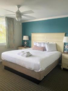 希尔顿黑德岛Seawatch at Island Club by Capital Vacations的一间卧室配有一张白色大床和蓝色的墙壁