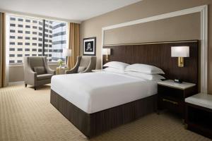 印第安纳波利斯印第安纳波利斯希尔顿酒店的一间大卧室,配有一张白色的大床和一把椅子