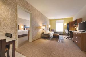 拉斐特拉斐特公园希尔顿欣庭套房酒店的酒店客房设有一间带一张床和一张书桌的卧室