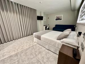 卡拉芭蒂纳Hotel El Paraíso的一间卧室配有一张大床和一张蓝色的沙发
