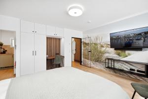 不莱梅Modernes Studio am Bremer Dom mit Balkon的一间白色卧室,配有一张大床和一台电视