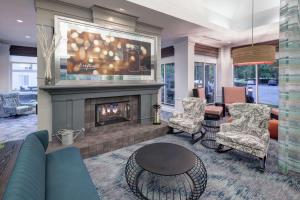 萨克拉门托Hilton Garden Inn Sacramento/South Natomas的客厅设有壁炉、沙发和椅子