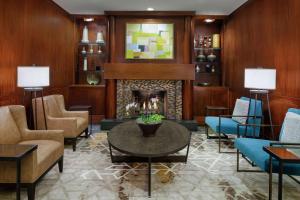 夏洛特DoubleTree Suites by Hilton Charlotte/SouthPark的客厅设有壁炉和蓝色椅子