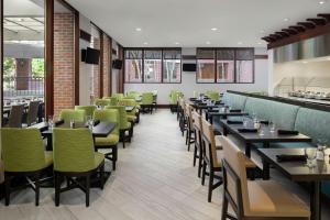 夏洛特DoubleTree Suites by Hilton Charlotte/SouthPark的用餐室配有桌子和绿色椅子