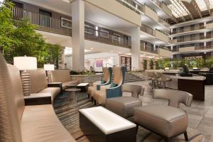 亚特兰大Embassy Suites by Hilton Atlanta Airport的大楼内带桌椅的大堂