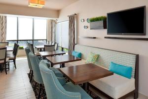 维洛海滩Hampton Inn Vero Beach Outlets的餐厅设有桌椅和平面电视。