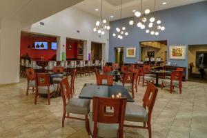 拉斯维加斯Hampton Inn Tropicana的一间带桌椅的餐厅和一间酒吧