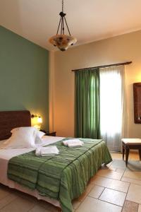 卢特拉Xenonas Afroditi的一间卧室配有一张带绿毯的床和窗户。