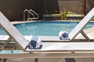 圣地亚哥圣地亚哥大使谷汉普顿酒店的游泳池旁几把椅子