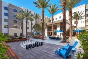 圣地亚哥圣地亚哥/海洋世界区希尔顿惠庭套房酒店的种有棕榈树的庭院和棋类游戏