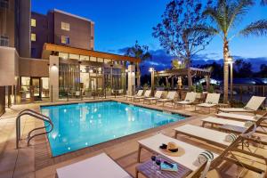 圣地亚哥圣地亚哥使命谷/动物园希尔顿惠庭套房酒店的一个带躺椅的游泳池和一间酒店