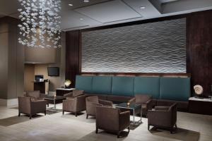 奥兰多Embassy Suites by Hilton Orlando Lake Buena Vista Resort的一间设有椅子和大屏幕的等候室