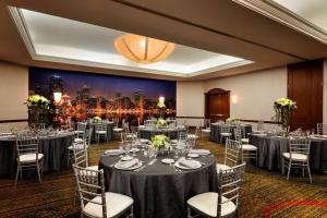 芝加哥Hilton Chicago Magnificent Mile Suites的宴会厅配有桌椅和城市画作