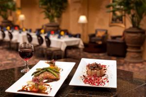 拉伯克拉伯克希尔顿合博套房酒店的一张桌子,上面放着两盘食物和一杯葡萄酒