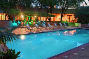 休斯顿休斯顿威斯契斯希尔顿酒店的一个带躺椅和灯光的大型游泳池