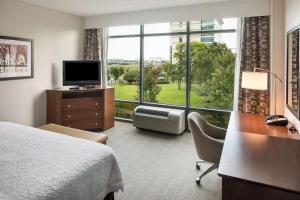 小石城小石城闹市区汉普顿旅馆及套房的酒店客房设有一张床和一个大窗户