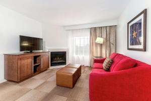 伯利恒伯利恒汉普顿酒店及套房的客厅配有红色沙发和平面电视