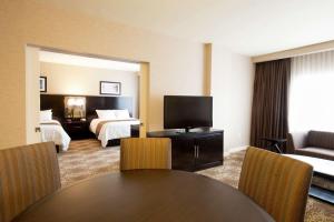 宾厄姆顿宾厄姆顿希尔顿逸林酒店的酒店客房带两张床和一张桌子以及椅子。