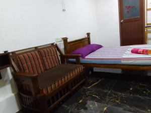 NochchiyagamaWilpattu buma的一间卧室配有一张床和一把椅子
