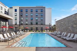 长滩加州长滩机场汉普顿酒店的一座带躺椅的游泳池和一座建筑