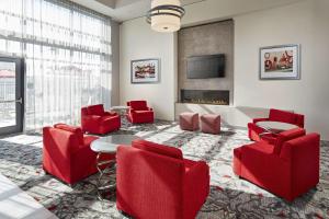 长滩加州长滩机场汉普顿酒店的客厅配有红色椅子和壁炉