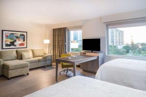 迈阿密Hampton Inn & Suites Miami Wynwood Design District, FL的酒店客房配有一张床和一张书桌及一台电视