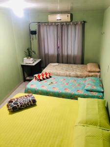 纳塔尔Pousada do Joaquimxdarc的一间小卧室,配有两张床和黄色床垫
