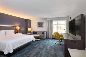 华盛顿汉普顿酒店华盛顿DC - 会展中心的酒店客房配有床、沙发和电视。