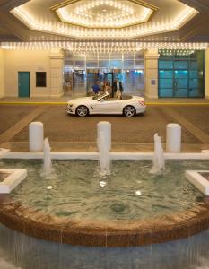 代托纳海滩代托纳比奇希尔顿酒店 的停在一座带喷泉的建筑中的白色汽车