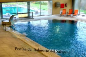 Casas del MonteCASA RURAL ARBEQUINA, Primavera en el Valle del Ambroz的一座带橙色椅子的游泳池