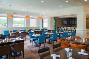 格拉斯顿伯里哈特福德南/格拉斯顿伯里希尔顿花园旅馆的一间配备有桌子和蓝色椅子的用餐室