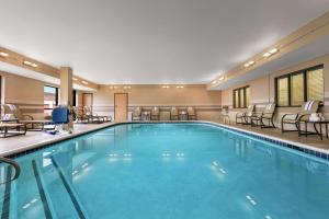 宾厄姆顿宾厄姆顿/约翰逊城希尔顿恒庭酒店的酒店的大型游泳池配有桌椅