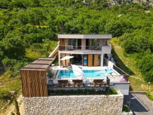 默克斯卡Palazzo Vimbula - Five Star Luxury Villa的山丘上带游泳池的房子