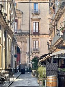 卡塔尼亚Sleep Inn Catania rooms - Affittacamere的城市里带桌椅的小巷