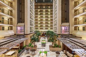 达拉斯Embassy Suites by Hilton Dallas Market Center的一张酒店大厅的图象,里面摆放着桌椅