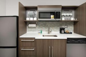 朗蒙特Home2 Suites By Hilton Longmont的厨房配有水槽和微波炉