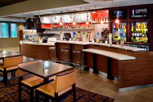 温莎Courtyard By Marriott Hartford Windsor Airport的餐厅内带桌椅的酒吧