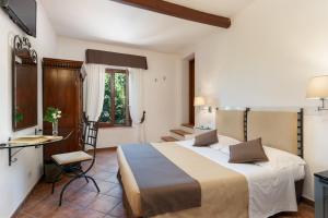 蒙特罗尼德阿尔比亚Hotel Ristorante Borgo Antico的酒店客房设有一张大床和一张桌子。