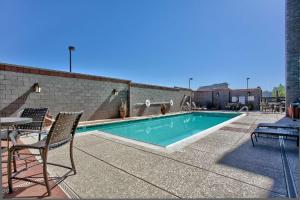斯科茨Hampton Inn & Suites Scottsdale at Talking Stick的庭院中一个带椅子和桌子的游泳池