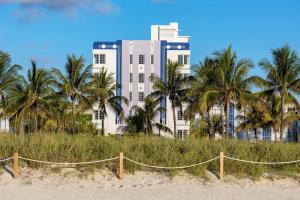 迈阿密海滩The Gabriel Miami South Beach, Curio Collection by Hilton的海滩前的棕榈树建筑