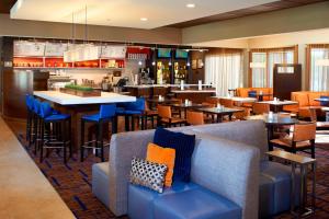迪尔菲尔德芝加哥迪尔菲尔德万怡酒店的一间设有蓝色桌椅的餐厅和一间酒吧