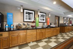 费尔维尤海茨圣路易斯/菲尔维海茨汉普顿酒店的厨房设有木制橱柜和 ⁇ 格地板。